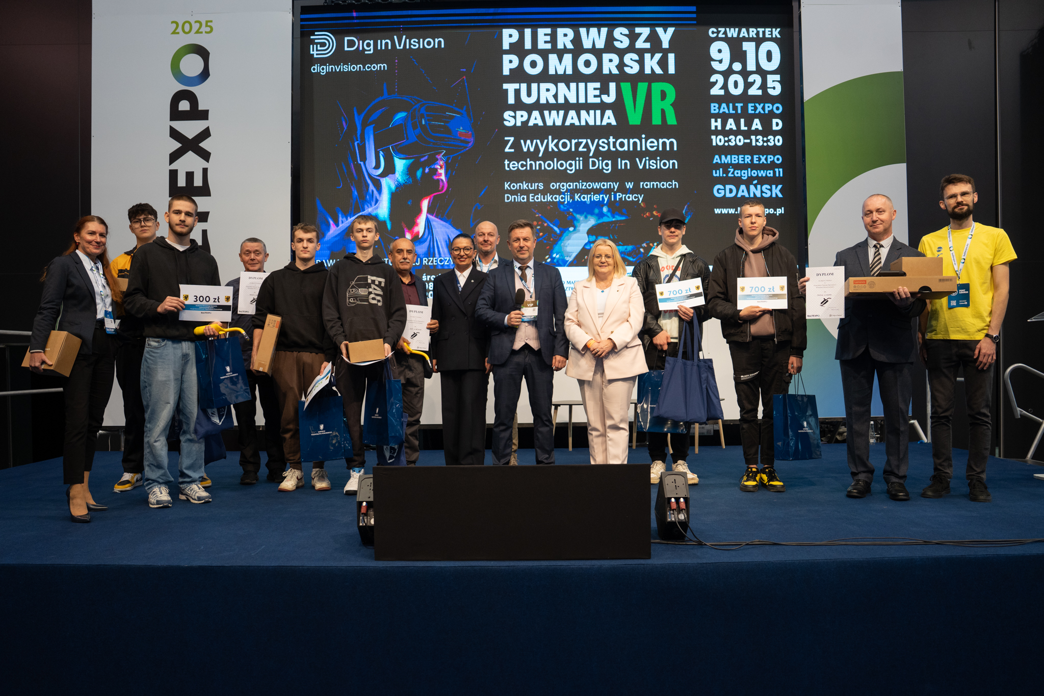 grupa zwycięsców na scenie pozuje do zdjęcia